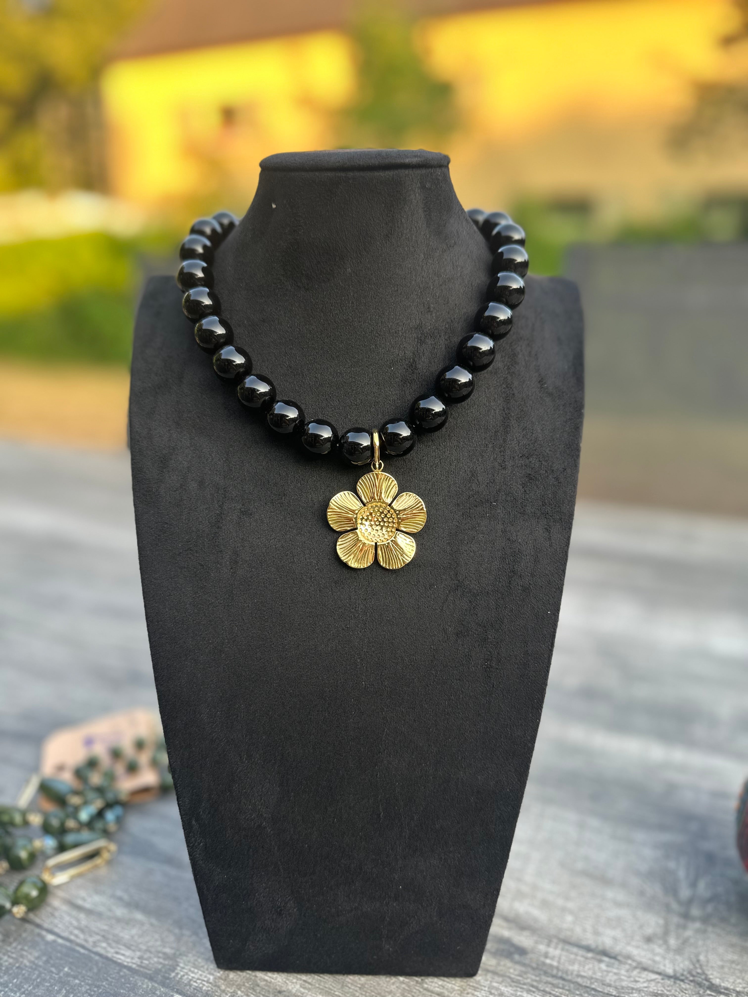 Zwarte kralenketting met gouden bloem