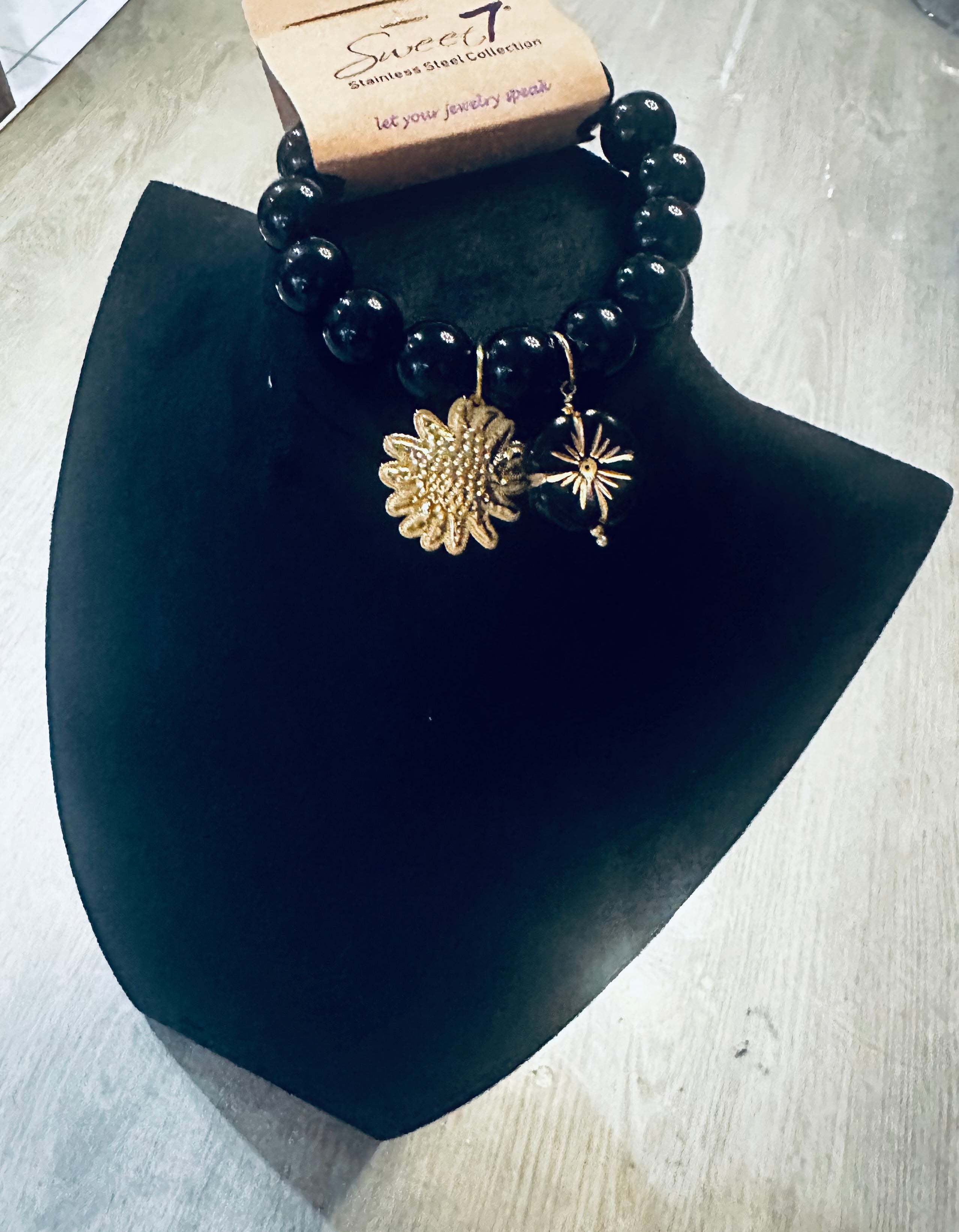 Zwarte kralenarmband met goudkleurige bloem